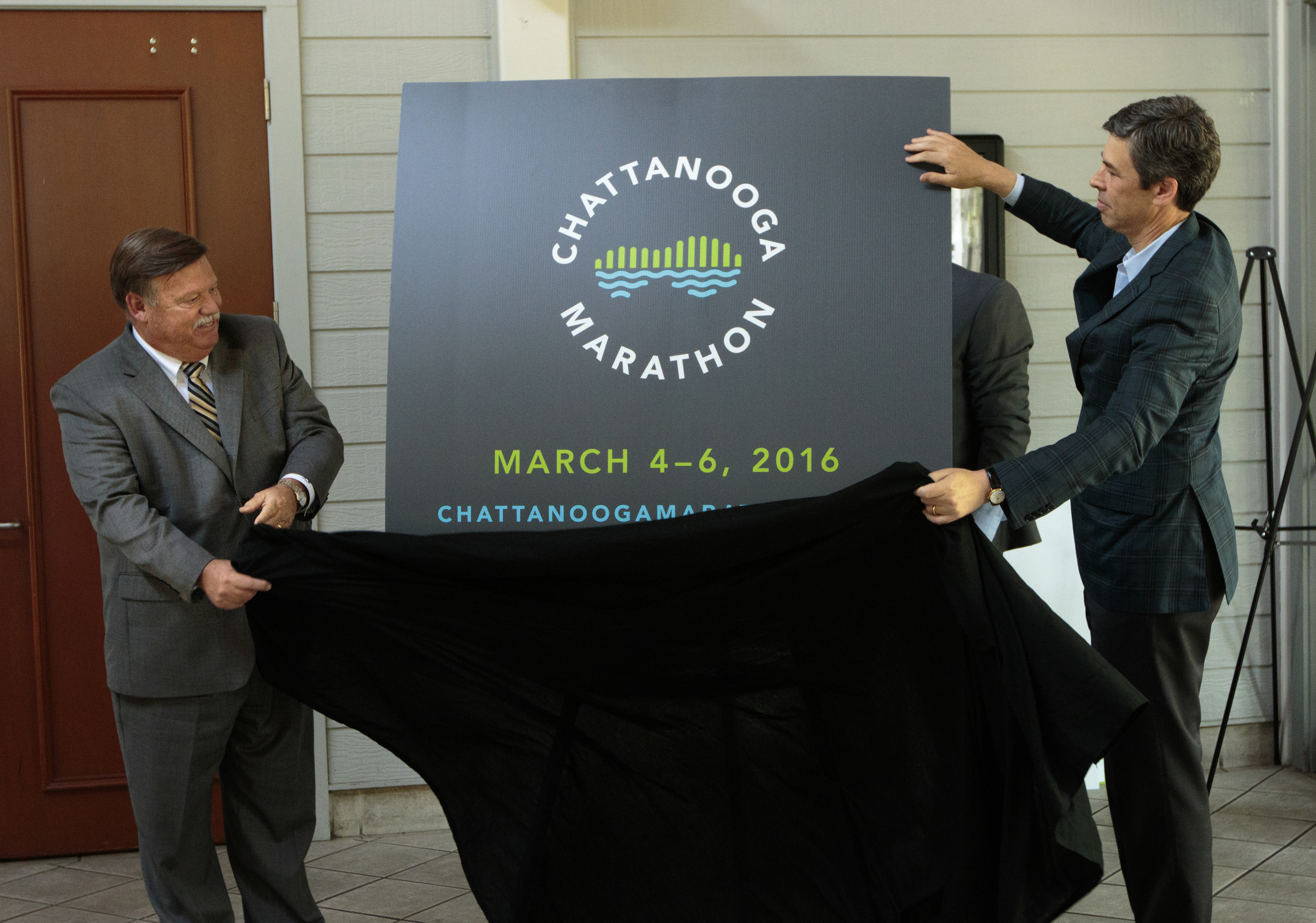 Staff photo by Doug Strickland
Hamilton County Mayor Jim Coppinger, left, and Chattanooga Mayor Andy Berke unveil the new Chattanooga Marathon logo at a news conference Thursday, June 18, 2015, at Coolidge Park in Chattanooga, Tenn. The marathon is set to take place March 4-6 of 2016.