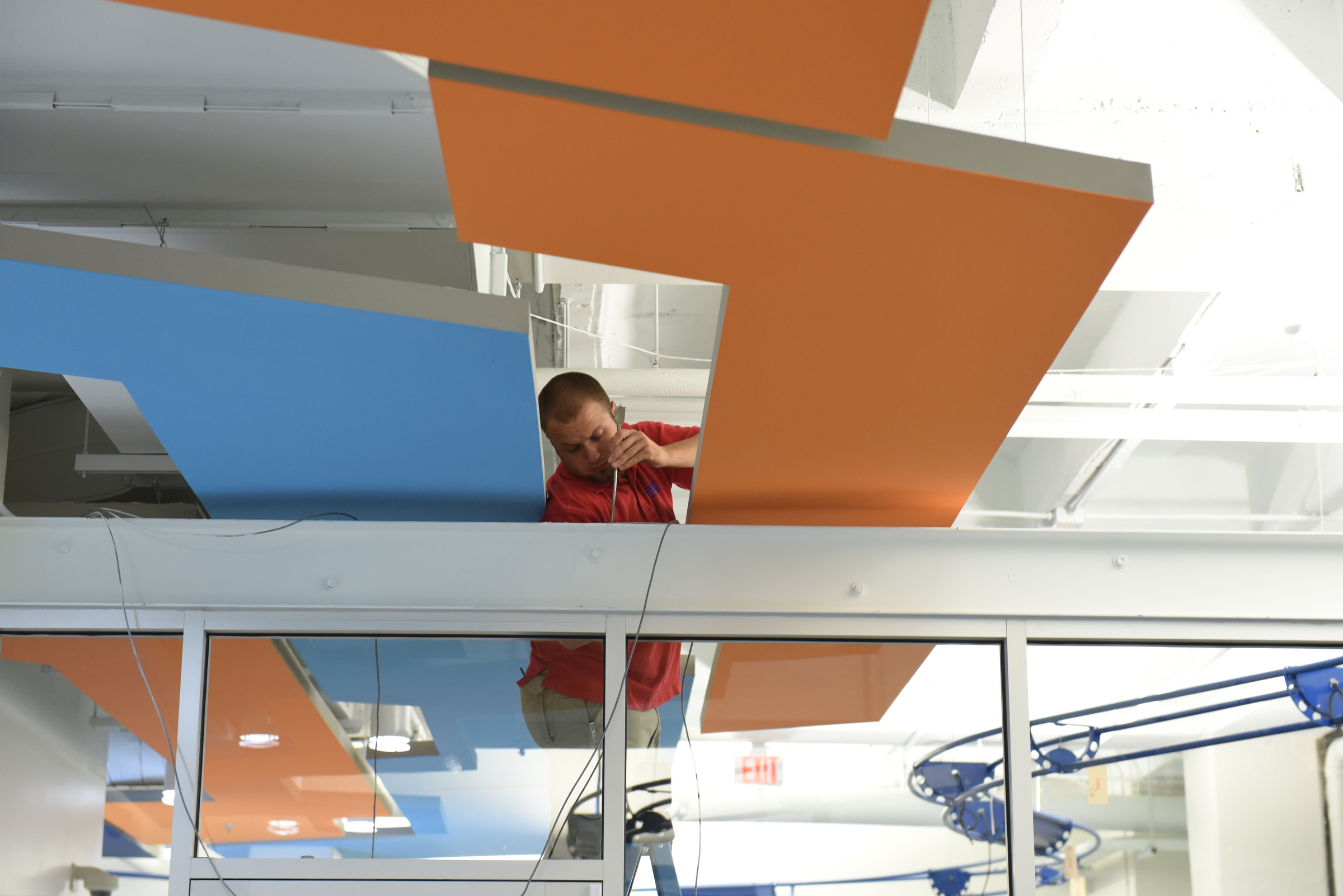Staff photo by John RawlstonERMC employee Chad Neal installs security equipment at TechTown.