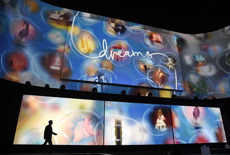 
              FILE - In this Monday, June 15, 2015 file photo, Asad Qizilbash, head of software marketing for Sony Computer Entertainment America, walks out onstage as graphics from the video game "Dreams" are displayed during the Sony Playstation at E3 2015 news conference at the Los Angeles Sports Arena in Los Angeles. The video-game industry’s annual Electronic Entertainment Expo, which wrapped up Thursday at the Los Angeles Convention Center is an overwhelming, exhausting experience - so many games, so little time.  With exclusive games the best way to attract buyers, Sony’s PS4 has “Uncharted 4: A Thief’s End,” “The Last Guardian,” “Horizon: Zero Dawn,” “Dreams” and the spooky “What Remains of Edith Finch.” (Photo by Chris Pizzello/Invision/AP, File)
            