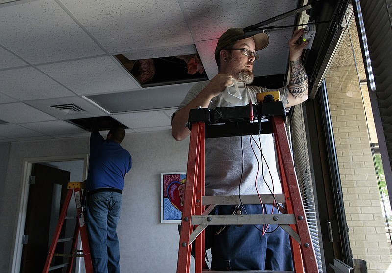 Staff photo by Doug Strickland
Marc Benton, right, and Dale Brewster with Gallaher & Associates work to install a security system Wednesday, June 17, 2015, at the Family Justice Center in Chattanooga, Tenn. The center is scheduled to launch July 1st.