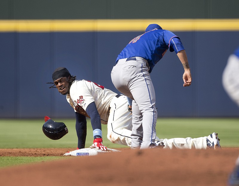 Atlanta Braves center fielder Cameron Maybin, left, steals second base as New York Mets shortstop Wilmer Flores (4) applies the late tag in the first inning of a baseball game Sunday, June 21, 2015, in Atlanta. Atlanta won 1-0.