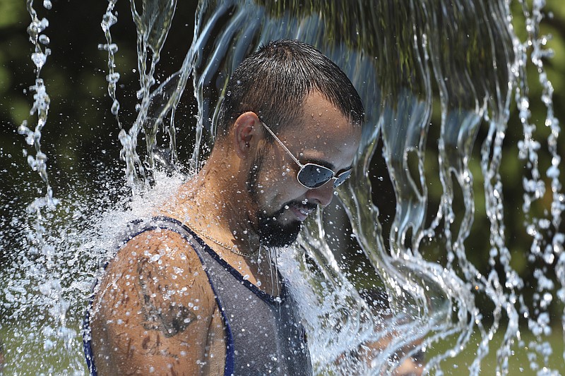 Jose Ramirez cools off under a water feature at Warner Park Pool and Spray Park on Monday.