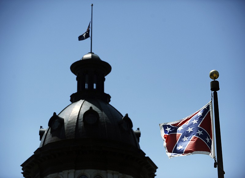 
              In this June 19, 2015, photo, a Confederate flag flies near the South Carolina Statehouse in Columbia, S.C.  Whether South Carolina should continue to fly the Confederate flag on its statehouse grounds is the latest in a series of issues to arise this summer challenging the GOP’s effort to build the young and diverse coalition of voters it likely needs to win the White House.  (AP Photo/Rainier Ehrhardt)
            