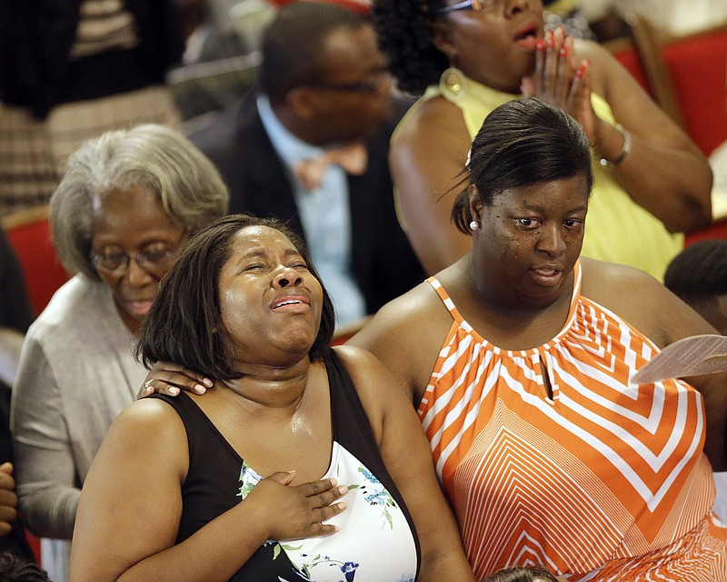 
              Parishioners sing at the Emanuel A.M.E. Church four days after a mass shooting that claimed the lives of its pastor and eight others on Sunday, June 21, 2015, in Charleston, S.C. (AP Photo/David Goldman, Pool)
            