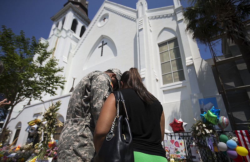 U.S. Army Spc. Ron Leary, left and Astride Leary, of Savannah, Ga., pray at a sidewalk memorial in memory of the shooting victims in front of Emanuel AME Church on Monday, June 22, 2015, in Charleston, S.C.