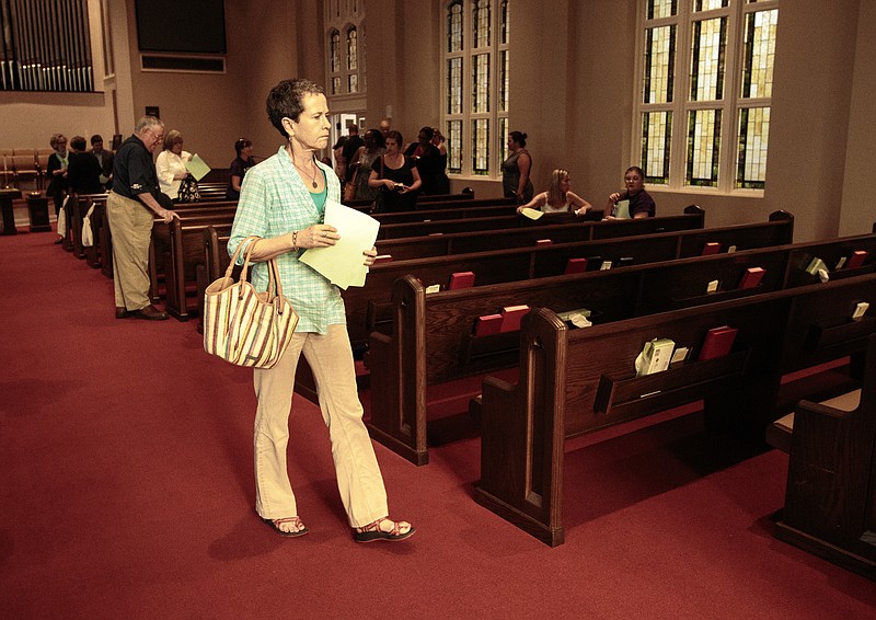 Staff photo by Doug Strickland
Katie Larue carries a stack of surveys to volunteers at the close of a "Counting the Cost" meeting held Tuesday, June 23, 2015, at St. Elmo United Methodist Church in Chattanooga, Tenn. The Tennessee Justice Coalition is traveling the state holding these community meetings in response to the Legislature's decision not to expand Medicaid.