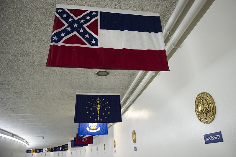 
              The Mississippi flag hangs, with the other state flags, in the subway between the U.S. Capitol and Dirksen Senate Office Building in Washington, Tuesday, June 23, 2015. In the wake of a massacre at a black church in Charleston, S.C., a bipartisan mix of officials across the country is calling for the removal of Confederate flags and other symbols of the Confederacy. Leaders of the Republican-controlled state of Mississippi are divided on whether to alter the state's flag, a corner of which is made up of the Confederate battle flag.  (AP Photo/Cliff Owen)
            