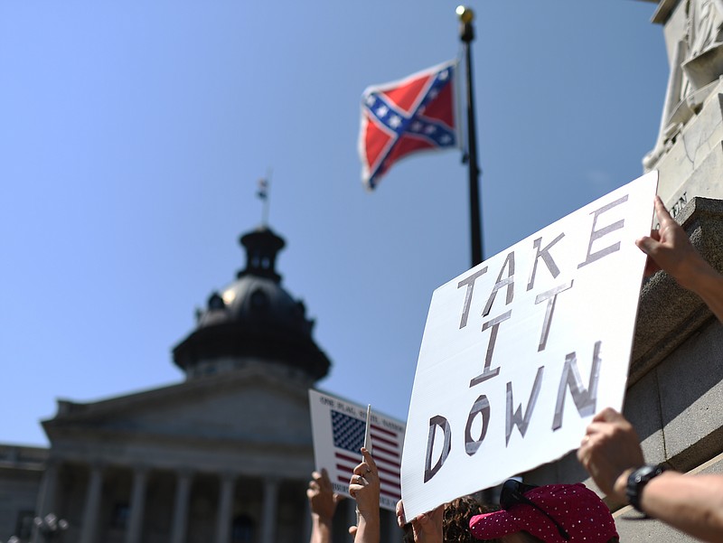 Protesters hold a sign during a rally to take down the Confederate flag at the South Carolina Statehouse, Tuesday, June 23, 2015, in Columbia, S.C.