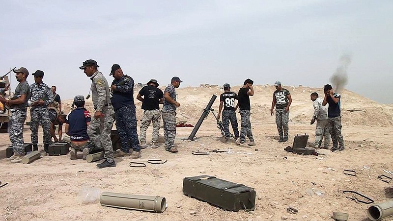 In this Saturday, June 20, 2015 photo, Iraqi security forces fire mortar shells at Islamic State group positions on the outskirts of Ramadi, the capital of Iraq's Anbar province, 115 kilometers (70 miles) west of Baghdad. The forces in Ramadi have been fighting against the IS group over a month since the city fell for the second time to the extremists. (AP Photo)