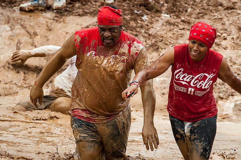 Two of the 3,000 or so competitors in last year's Chattanooga Mud Run make their way through the 5k course at Greenway Farm in this file photo.