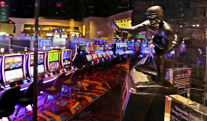 
              The Heisman Trophy, won in 1984 by Boston College quarterback Doug Flutie, is displayed at the Plainridge Park Casino in Plainville, Mass., Tuesday, June 23, 2015. The casino, a slot machine parlor, is scheduled to open on Wednesday June, 24, 2015. The Plainridge Park Casino represents the first gambling destination to open since state lawmakers approved a casino law in 2011. (AP Photo/Charles Krupa)
            