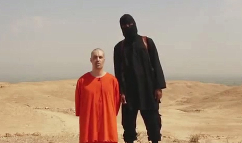 
              FILE - This undated file image made from a video released by Islamic State militants Tuesday, Aug. 19, 2014, purports to show the killing of journalist James Foley by the militant group. In a softening of long-standing policy, the Obama administration will tell families of Americans held by terror groups that they can communicate with the captors and even pay ransom without fear of prosecution, part of a broad review of U.S. hostage policy that will be released June 24. Four Americans have been killed by the Islamic State since last summer: journalists Foley and Steven Sotloff and aid workers Peter Kassig and Kayla Mueller. After the release of gruesome videos showing the beheadings of some hostages, Obama approved an airstrike campaign against the Islamic State in both Iraq and Syria.  (Militant website via AP, File)
            