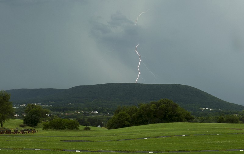 
              Lightning strikes over Mount Nittany in State College, Pa., Tuesday, June 23, 2015, as a thunderstorm moves through Centre County. Severe weather that pounded the Midwest and spawned tornadoes shifted on Tuesday to the East Coast, where tornado warnings were issued in several states and rainstorms were strong enough to stop train service. (Nabil K. Mark/Centre Daily Times via AP)
            