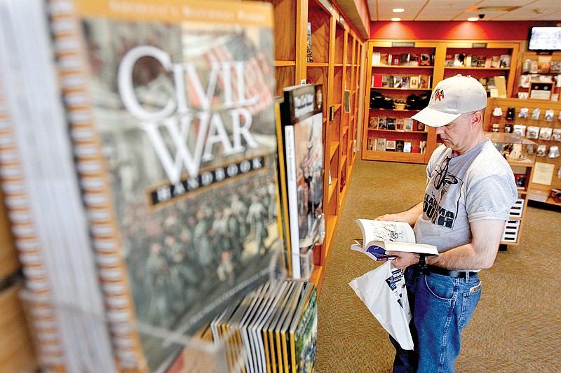 Staff file Photo by Dan HenryLance Aguirre from Denver, Colo., peruses Civil War-themed books in the Chickamauga Battlefield Visitors Center. The park announced Confederate flag merchandise will no longer be sold at the store.