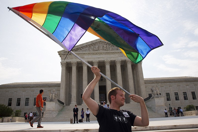 The Associated PressJohn Becker, 30, of Silver Spring, Md., waves a rainbow flag in support of gay marriage outside of the Supreme Court in Washington, Thursday.