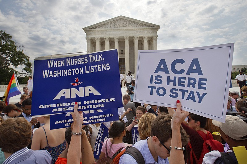 Supporters of the Affordable Care Act hold up signs as the opinion for health care is reported outside of the Supreme Court in Washington, Thursday June 25, 2015. The Supreme Court on Thursday upheld the nationwide tax subsidies under President Barack Obama's health care overhaul, in a ruling that preserves health insurance for millions of Americans. The justices said in a 6-3 ruling that the subsidies that 8.7 million people currently receive to make insurance affordable do not depend on where they live, under the 2010 health care law.