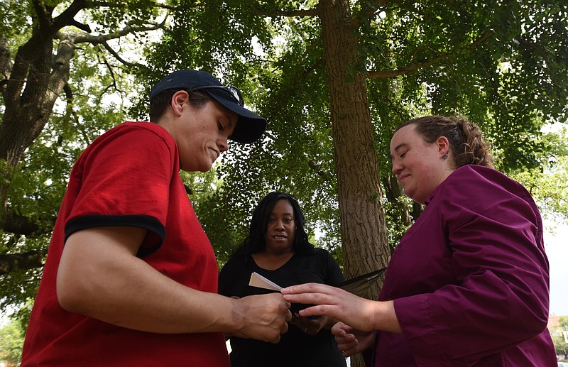 Celebrant Shaun Cox, center, performs the wedding ceremony Rhiannan Pierce, left, and as Phyllis Wood exchange rings Friday, June 26, 2015 at the Hamilton County Courthouse.