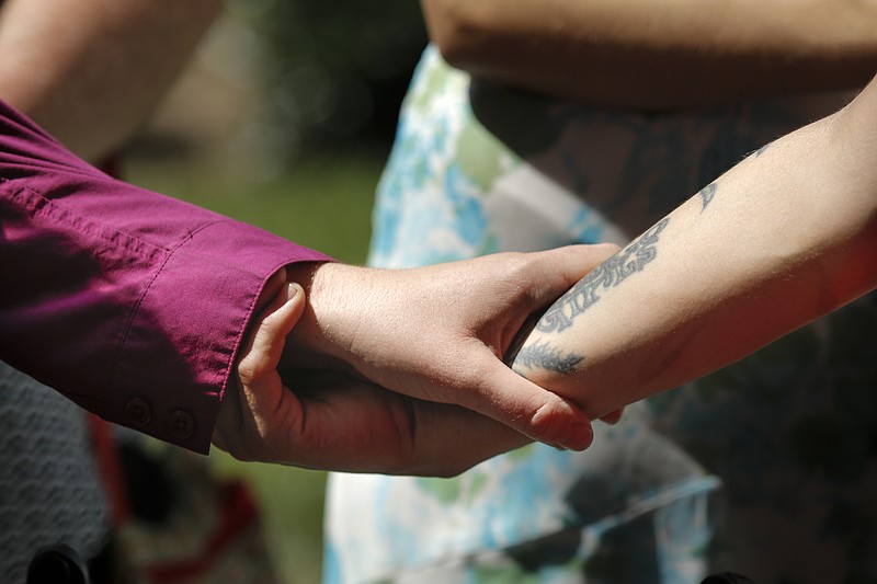 Phyllis Wood, left, and Rhiannan Pierce hold hands after becoming Hamilton County's first officially wed same-sex couple during a ceremony Friday, June 26, 2015, on the lawn of the Hamilton County Courthouse in Chattanooga, Tenn. The United States Supreme Court ruled Friday that state bans on same sex marriages were unconstitutional.