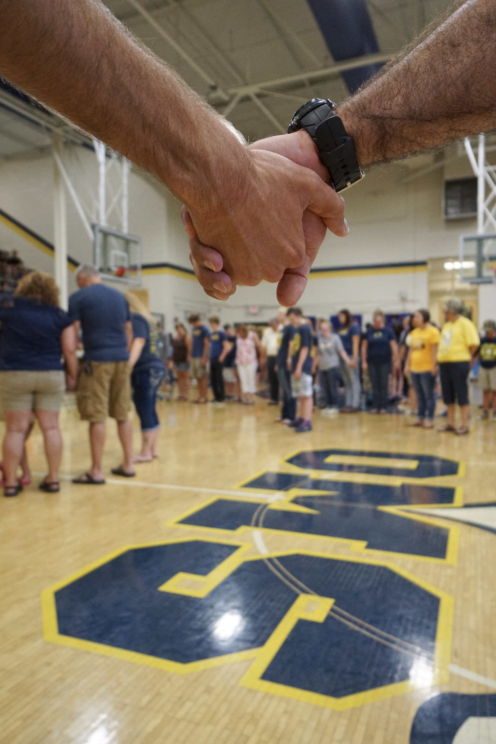 Photo by Dan Henry / The Chattanooga Times Free Press. Kevin White, left, and Matthew Fischer, right, hold hands as students, friends and family pray during a candlelight vigil on Friday June 26, 2015 for Ocoee Middle School's band director, Brian Gallaher, who was one of the six people killed in a crash on I-75 late Thursday evening.