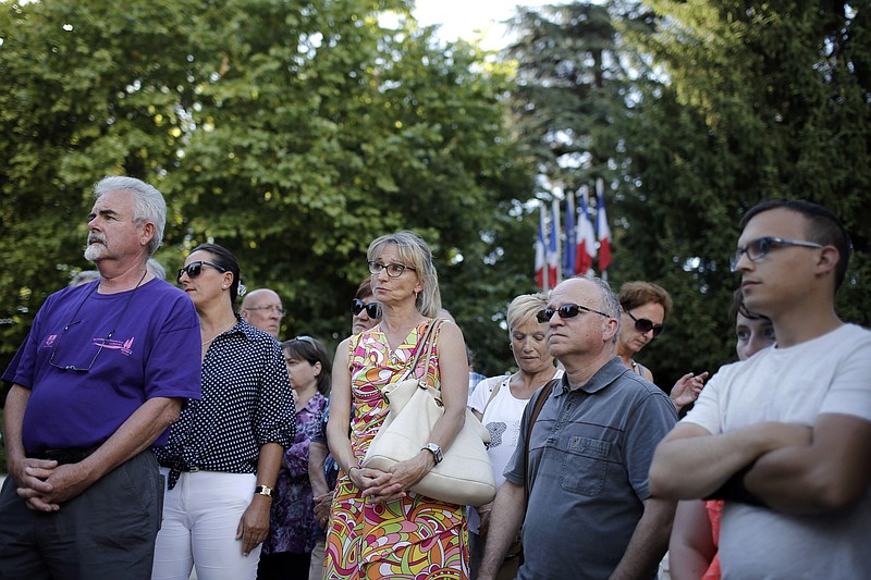People gather in Bourgoin, southeast of Lyon, France, to pay their respects to the victim of the attack which took place earlier in Saint-Quentin-Fallavie on Friday, June 26, 2015. A man with suspected ties to French Islamic radicals rammed a car Friday into an American gas factory in southeastern France, triggering an explosion that caused injuries, officials said. 