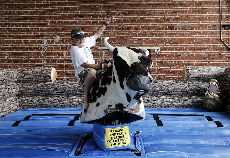 Staff photo by Doug Strickland
Jack Menard rides a mechanical bull at the Man Xpo on Saturday, June 27, 2015, at the First Tennessee Pavilion in Chattanooga, Tenn. The expo featured vendors and attractions offering manly pursuits.
