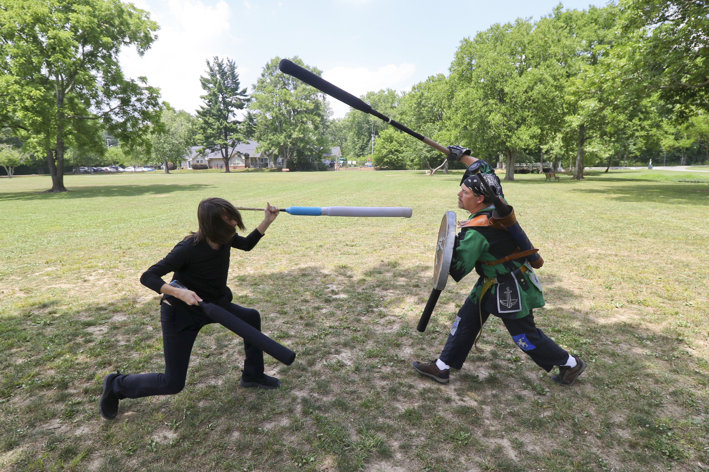 Staff Photo by Dan Henry. Josh Hynes "Popo", left, and Jason Parker "Deryk MacCoill", right, battle during an Amtgard practice at Heritage Park in East Brainerd, Tenn., on Wednesday, June 24, 2015. Amtgard is an international organization where players use padded weapons to battle each other in medieval and fantasy based game scenarios.
