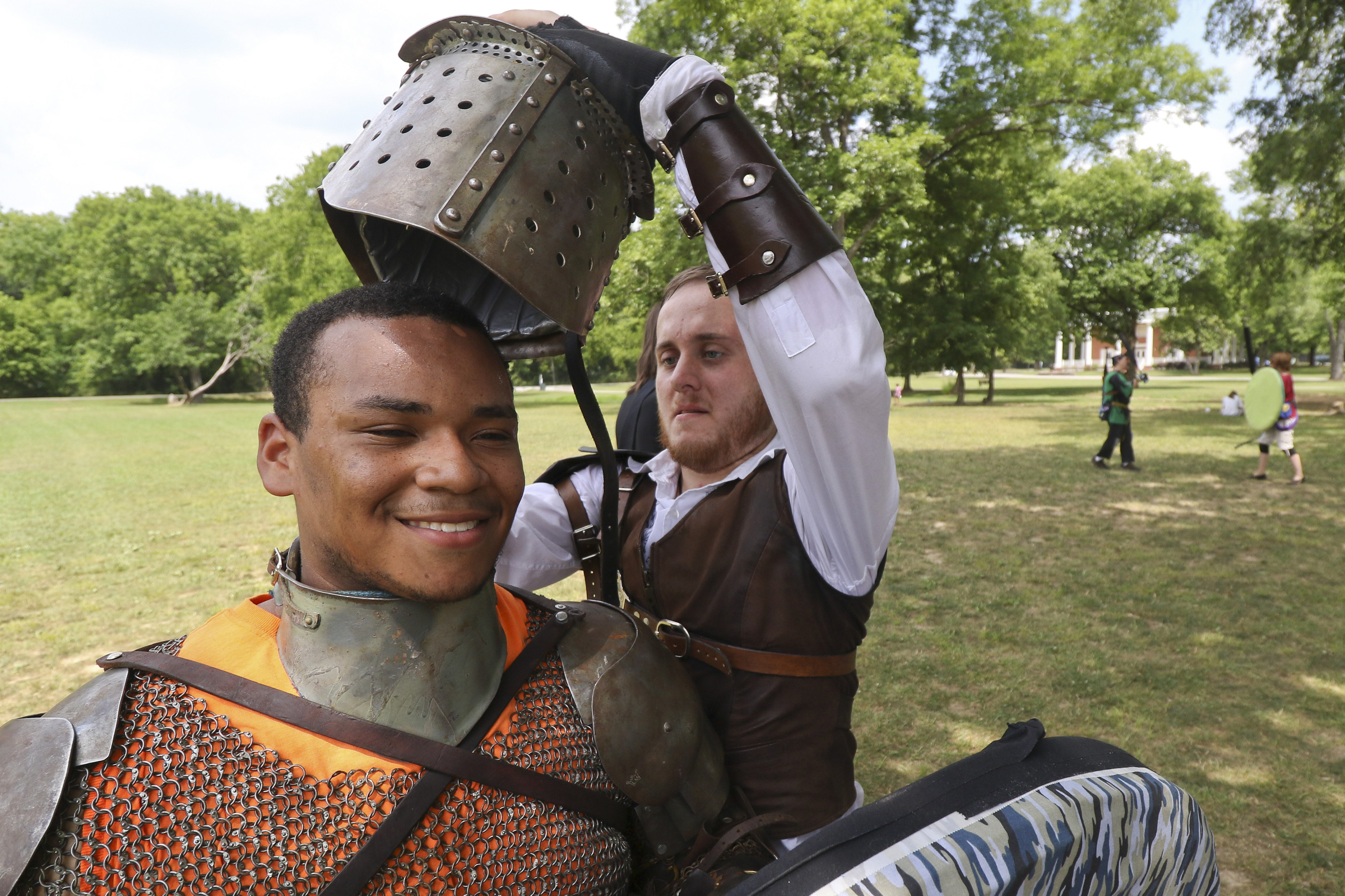 Staff Photo by Dan Henry. Felipe Argueta "Captain Cuddles" left, is aided by Nicholas Hoffman "Vayne" right while putting on a suit of armor before battling friends during an Amtgard practice at Heritage Park in East Brainerd, Tenn., on Wednesday, June 24, 2015. Amtgard is an international organization where players use padded weapons to battle each other in medieval and fantasy based game scenarios.