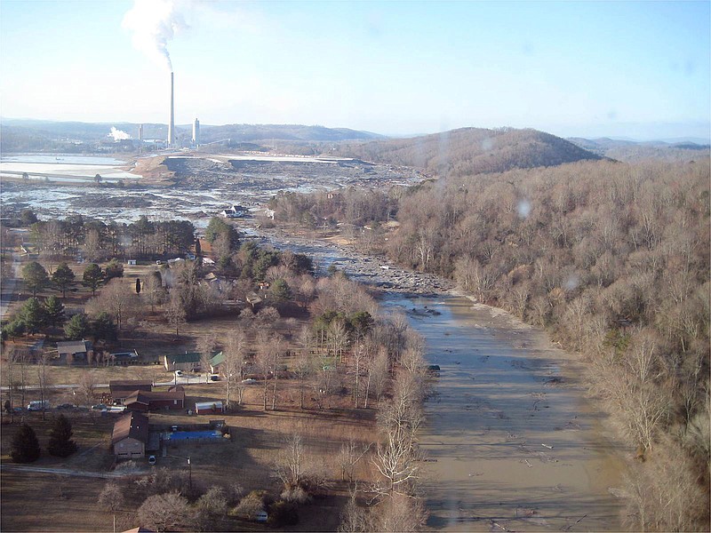 This file handout photograph provided by the Tennessee Valley Authority in January 2009 shows pollution from the smokestack of the Kingston Fossil Plant in Kingston, Tenn., before the new scrubber was completed. Additionally the photo shows the coal ash that was spilled from a storage pond there just days before on Dec. 22, 2008. The toxics-laden ash included mercury, arsenic and other dangerous substances when it ozzed onto nearly 400 acres in the Swan Pond community and the Emory River. The spill has been cleaned up and the scrubber is now operational. (AP Photo/TVA, File)