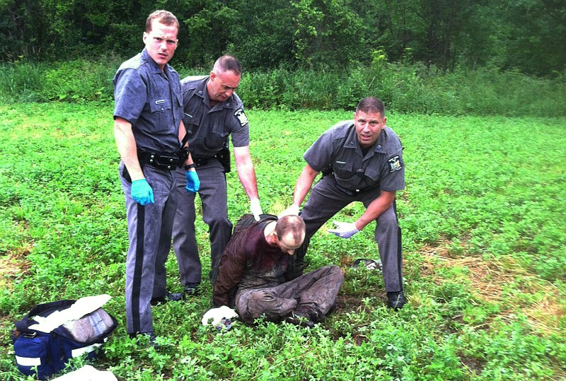 
              Police stand over David Sweat after he was shot and captured near the Canadian border Sunday, June 28, 2015, in Constable, N.Y. Sweat is the second of two convicted murderers who staged a brazen escape three weeks ago from a maximum-security prison in northern New York. His capture came two days after his escape partner, Richard Matt, was shot and killed by authorities. (AP Photo)
            