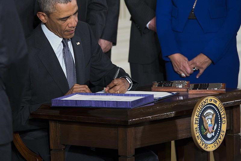 
              President Barack Obama signs H.R. 2146 Defending Public Safety Employees Retirement Act and H.R. 1295 Trade Preferences Extension Act of 2015, Monday, June 29, 2015, in the East Room of the White House in Washington. The president signed into law two hard-fought bills giving him greater authority to negotiate international trade deals and providing aid to workers whose jobs are displaced by such pacts (AP Photo/Evan Vucci)
            