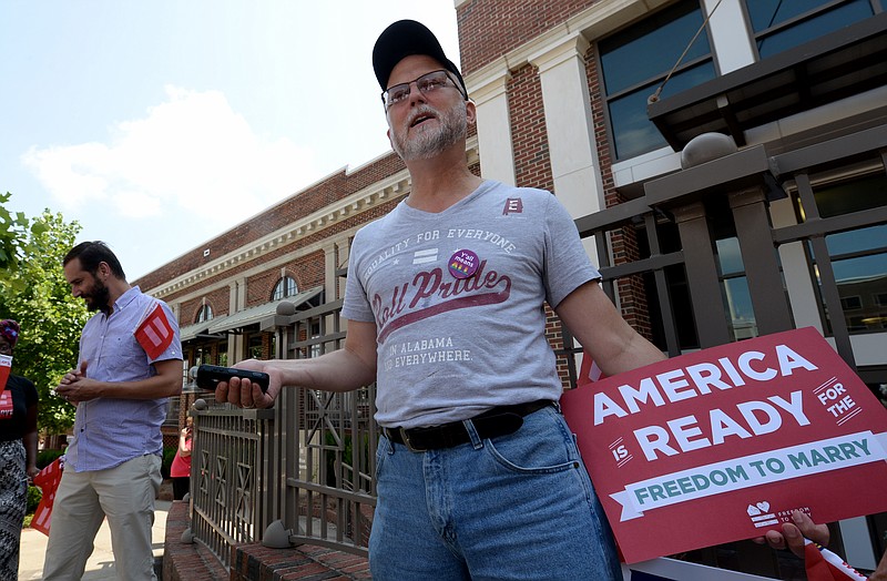 Paul Hard stands outside the Montgomery County Probate Office to celebrate the U.S. Supreme Court's decision that sex couples have a right to marry anywhere in the United States on Friday, June 26, 2015, in Montgomery, Ala. The court's 5-4 ruling means the remaining 14 states, in the South and Midwest, will have to stop enforcing their bans on same-sex marriage.