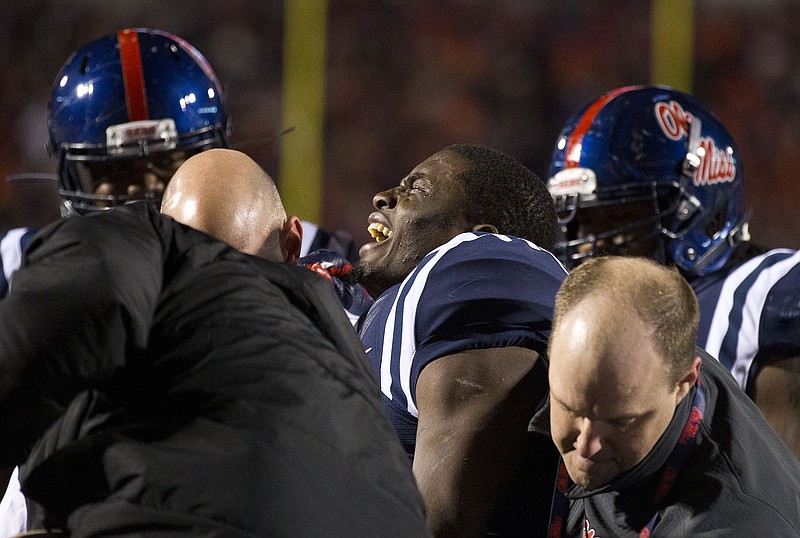 Mississippi wide receiver Laquon Treadwell, center, reacts after being injured during the second half of an NCAA college football game against Auburn, Saturday, Nov. 1, 2014, in Oxford, Miss. Treadwell fumbled the ball at the Auburn goal line, he was injured and taken off the field. (AP Photo/Brynn Anderson)