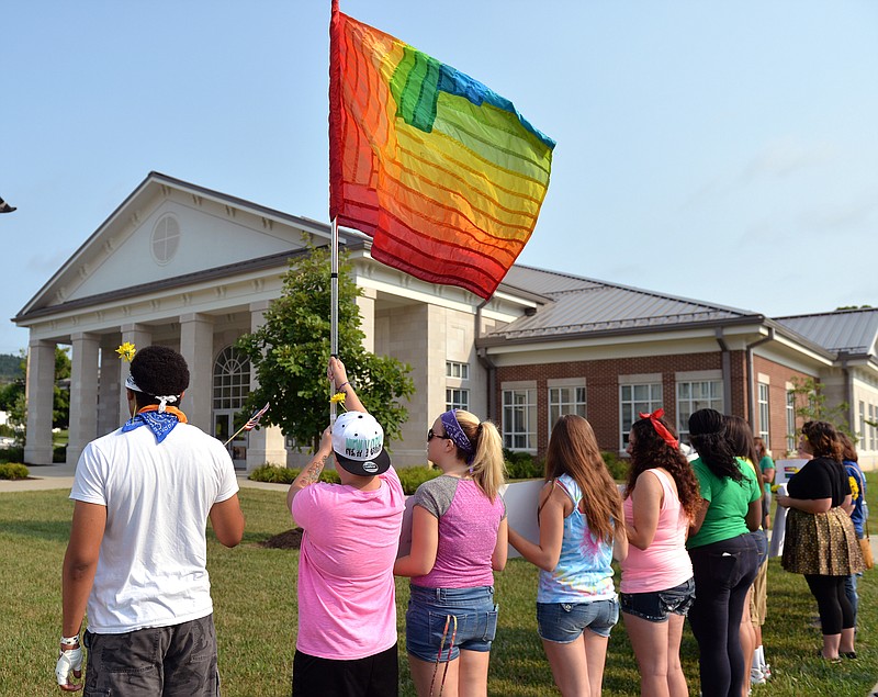 
              Protesters waive a rainbow flag on the front lawn of the Rowan County Judicial Center, Tuesday, June 30, 2015, in Morehead, Ky. The protest was being held against Rowan County Clerk Kim Davis, who, due to the ruling of the Supreme Court of the United States and her own religious beliefs, has refused to issue any marriage licenses in the county. (AP Photo/Timothy D. Easley)
            