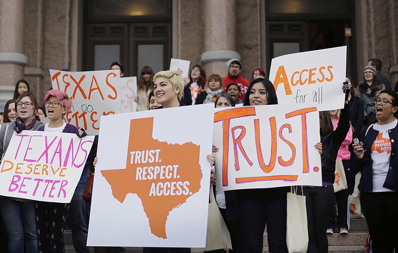 
              FILE - In this Feb. 26, 2015 file photo, college students and abortion rights activists hold signs during a rally on the steps of the Texas Capitol, in Austin, Texas. The Supreme Court refused on Monday, June 29, 2015, to allow Texas to enforce restrictions that would force 10 abortion clinics to close.  (AP Photo/Eric Gay, File)
            