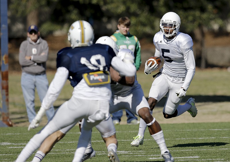 Bingo Morton carries the ball during a University of Tennessee at Chattanooga scrimmage at Scrappy Moore Field this spring. Denver Broncos quarterback Peyton Manning, the former University of Tennessee great, worked out with some of the Mocs at the field on Wednesday.