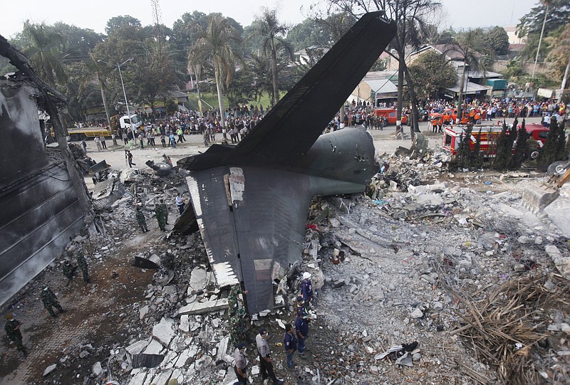 
              Rescuers search for victims at the site where an Indonesian air force transport plane crashed in Medan, North Sumatra, Indonesia, Wednesday, July 1, 2015. The Hercules C-130 plane crashed into a residential neighborhood in the country's third-largest city on June 30. (AP Photo/Binsar Bakkara)
            