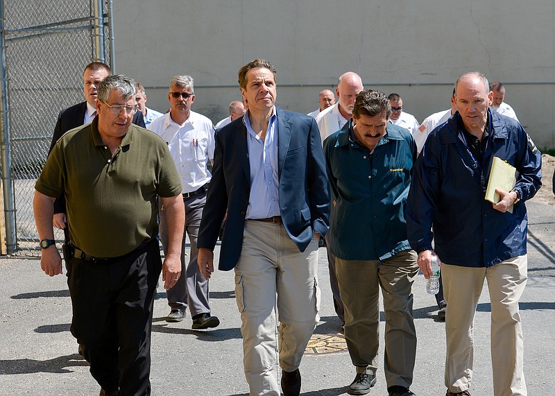 This June 6, 2015, photo provided by New York Gov. Andrew Cuomo's office shows Cuomo, second from left, walking with Steven Racette, left, superintendent of Clinton Correctional Facility, in Dannemora, N.Y.