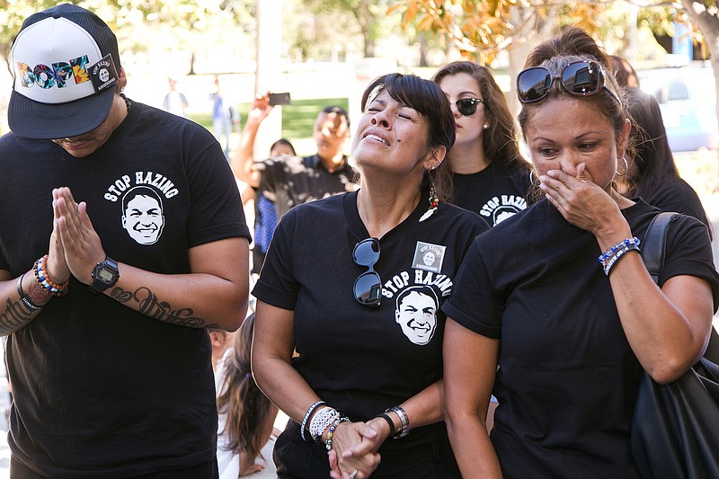 In this Sept. 5, 2014, file photo, relatives of the late Armando Villa, Joshua Castaneda, left, and his mother Martha Castaneda, and Villa's aunt, Maria Castaneda, right, react as California State University, Northridge CSUN President Dianne Harrison, reads a statement regarding Pi Kappa Phi Fraternity activities that lead to the death of CSUN student Armando Villa, at a news conference at the CSUN campus in Northridge, Calif.