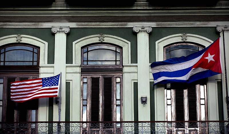 In this Jan. 19, 2015, file photo, a Cuban and American flag wave from the balcony of the Hotel Saratoga in Havana. 