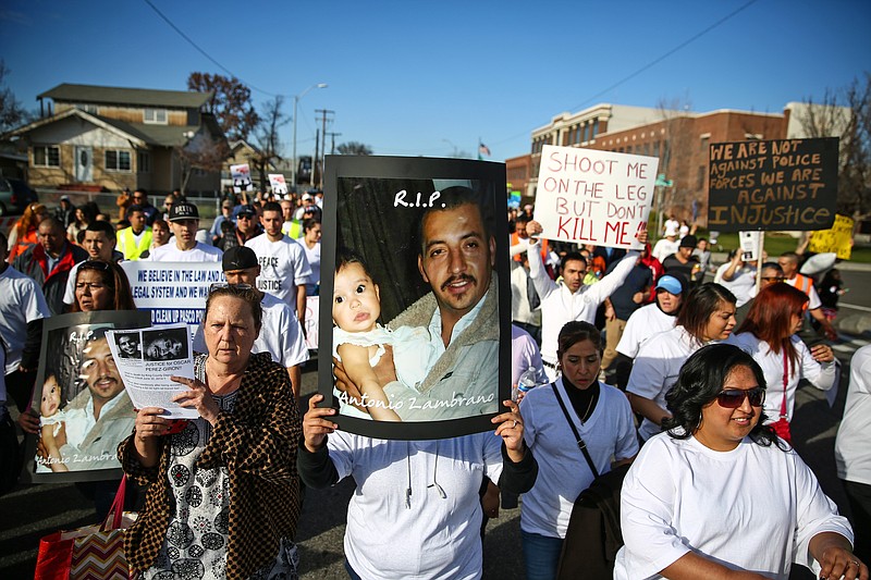 Marchers carry photos of police shooting victim Antonio Zambrano-Montes during a rally in Pasco, Wash., in this Feb. 14, 2015, file photo.