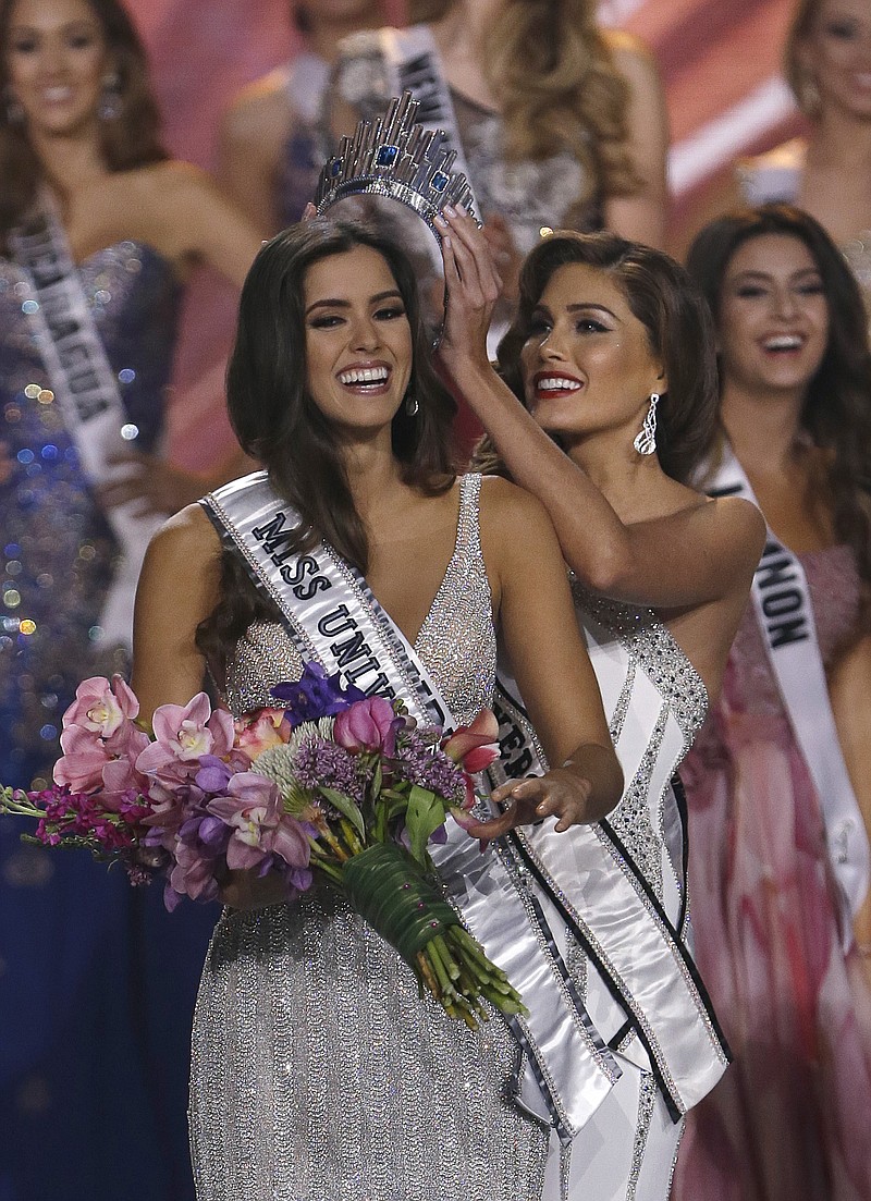 
              FILE - In this Jan. 25, 2015, file photo, reigning Miss Universe Gabriela Isler, right, crowns the new Miss Universe, Paulina Vega of Colombia, left, during the Miss Universe pageant in Miami, Sunday. Vega said on Thursday, July 2, 2015, that Donald Trump's recent comments against Mexican immigrants where hurtful and unfair, but she added that if the Miss Universe organization had any anti-latino or racist sentiments, she would not be in the position she is today. (AP Photo/Wilfredo Lee)
            