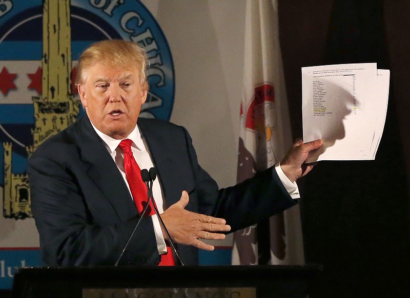 Republican presidential candidate Donald Trump casts a shadow against papers he used while speaking to members of the City Club of Chicago on Monday in Chicago.