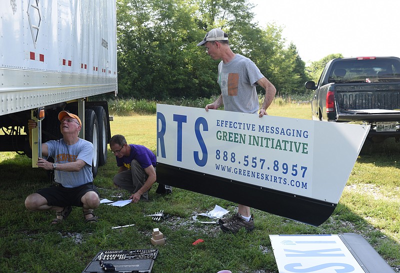 Staff photo by Tim Barber
Paul Jackson, right, art director for Greene Skirts, works with his father, Johnny Jackson, left, and Gary Crowson, back center, to install the first trailer skirts displaying an advertisement for Greene Skirts at Sign-Rite, Inc., in Chickamauga.