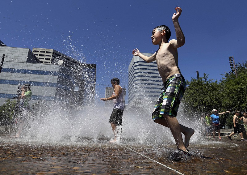 
              Children play in the Salmon Street Springs fountain in Portland, Ore., Wednesday, July 1, 2015. A heat advisory is in effect for Portland from noon Wednesday to 8 p.m. Thursday, according to the national weather service.  (AP Photo/Don Ryan)
            