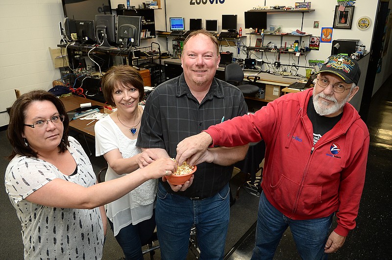 
              In this June 16, 2015 photo, Zoovio co-owner Marlo Anderson, center, and some of the National Day Calendar review committee, including, from left, Zoovio employees Amy LaVallie, Alice Anderson, and Nicholas Ressler, pose for a photo with a bowl of popcorn at the Mandan, N.D. business. Anderson says he started an online compendium of special days in 2013 called National Day Calendar after his love of popcorn piqued his curiosity about National Popcorn Day (Jan. 19). (AP Photo/Will Kincaid)
            