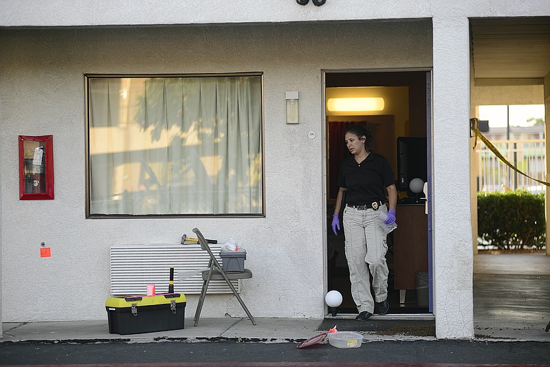 An Albuquerque Police Deptartment officer collects evidence July 1, 2015, after a man was killed and another injured during what police say was an altercation between the two late Tuesday at a Motel 6 in Albuquerque, N.M.