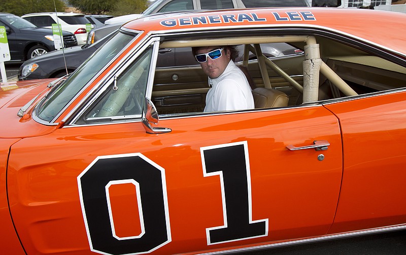 Golfer Bubba Watson drives off in the General Lee after playing in the pro-am at the Phoenix Open golf tournament in Scottsdale, Ariz., in this Feb. 1, 2012, file photo. Bubba Watson says he's painting over the Confederate flag on his car made popular in "The Dukes of Hazzard" television series.