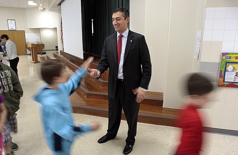 
              FILE - In this Jan. 31, 2014 file photo,Texas State Representative Giovanni Capriglione gives high-fives after speaking to second-grade students at Keller-Harvel Elementary in Keller, Texas. Capriglione authored a bill passed by the Texas legislature to start keeping its gold holdings within in its own borders. But what makes sense politically in such a sovereignty-loving place is creating a logistical conundrum. The law doesn’t say where the depository would be or how it should be built or secured.  (Ian McVea/ The Fort Worth Star-Telegram via AP, File)
            
