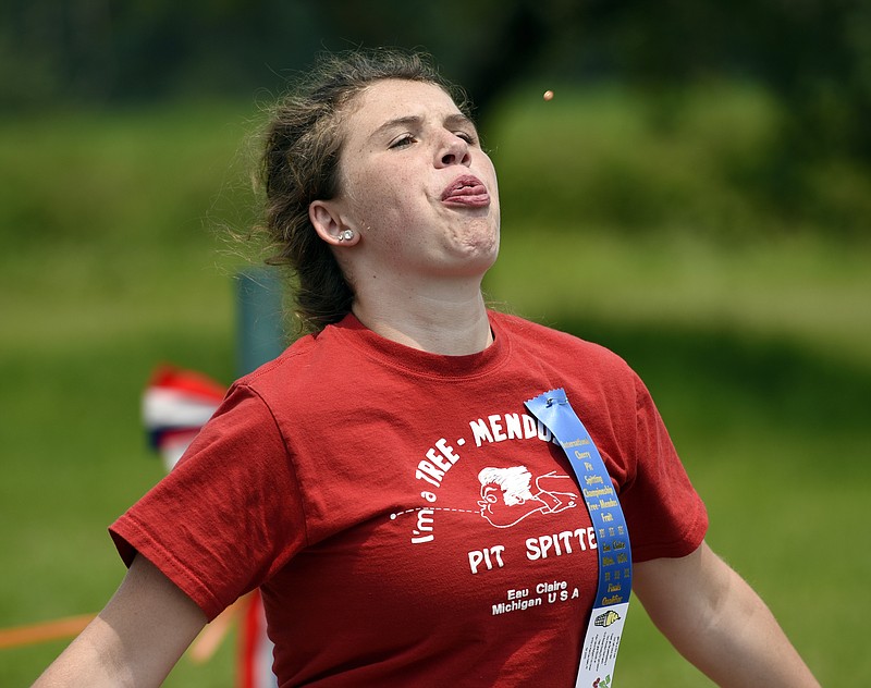 Megan Ankrapp, 15, from Buchanan, Mich., lets loose a 49 foot, 1/4 inch spit to win the women's category during the 42nd International Cherry Pit-Spitting Championship at Tree-Mendus Fruit Farm in Eau Claire, Mich., on Saturday, July 4, 2015. 