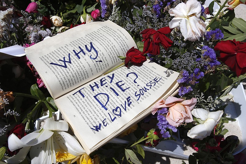 In this June 28, 2015 file photo, a book and flowers lay at the scene of the attack in Sousse, Tunisia. Tunisia's state news agency says the country's president is declaring a state of emergency more than a week after a beach attack targeting foreign tourists that killed 38 people. 